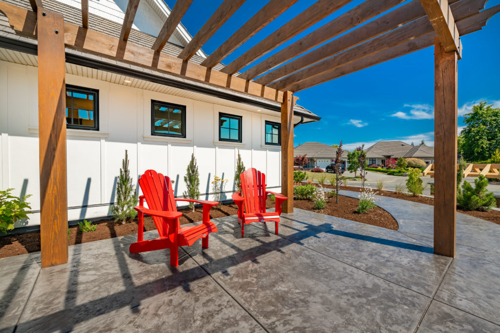 A beautiful backyard featuring a brown pergola and a stamped concrete patio, expertly crafted by custom patio installers in Simi Valley. These skilled concrete contractors specialize in paved patio construction and patio construction, enhancing outdoor living spaces with their craftsmanship.