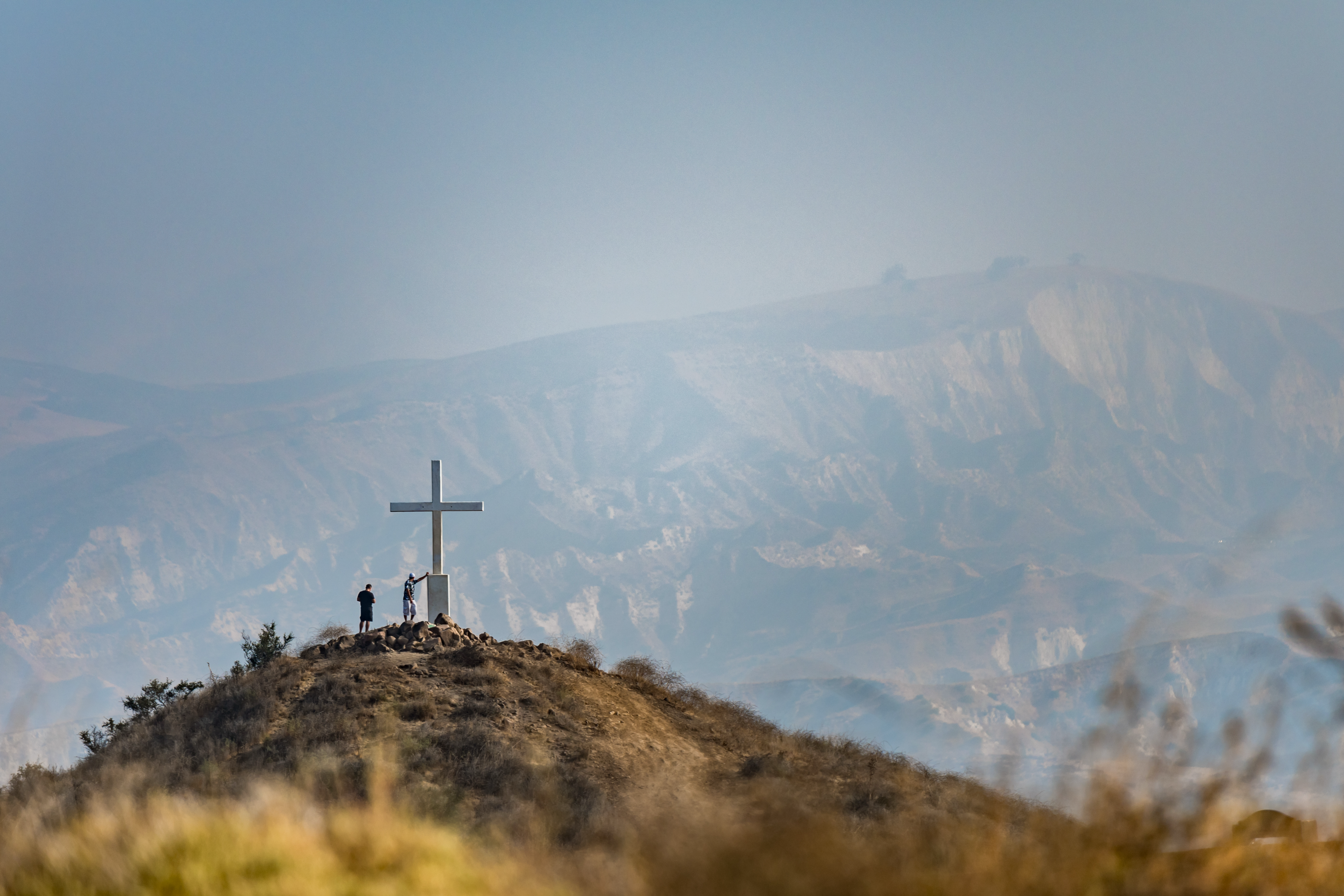 Iconic cross on top of a mountain in Simi Valley, symbolizing the craftsmanship of local concrete contractors. Renowned for their custom patio installation in Simi Valley, these experts also excel in driveway construction, patio construction, and block wall installation, enhancing residential spaces.