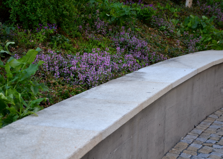 A beautiful backyard featuring an elegant retaining wall, expertly built by top concrete contractors in Simi Valley. These skilled retaining wall installers offer exceptional masonry block wall services, specializing in block wall installation and retaining wall installation with precision and quality craftsmanship.