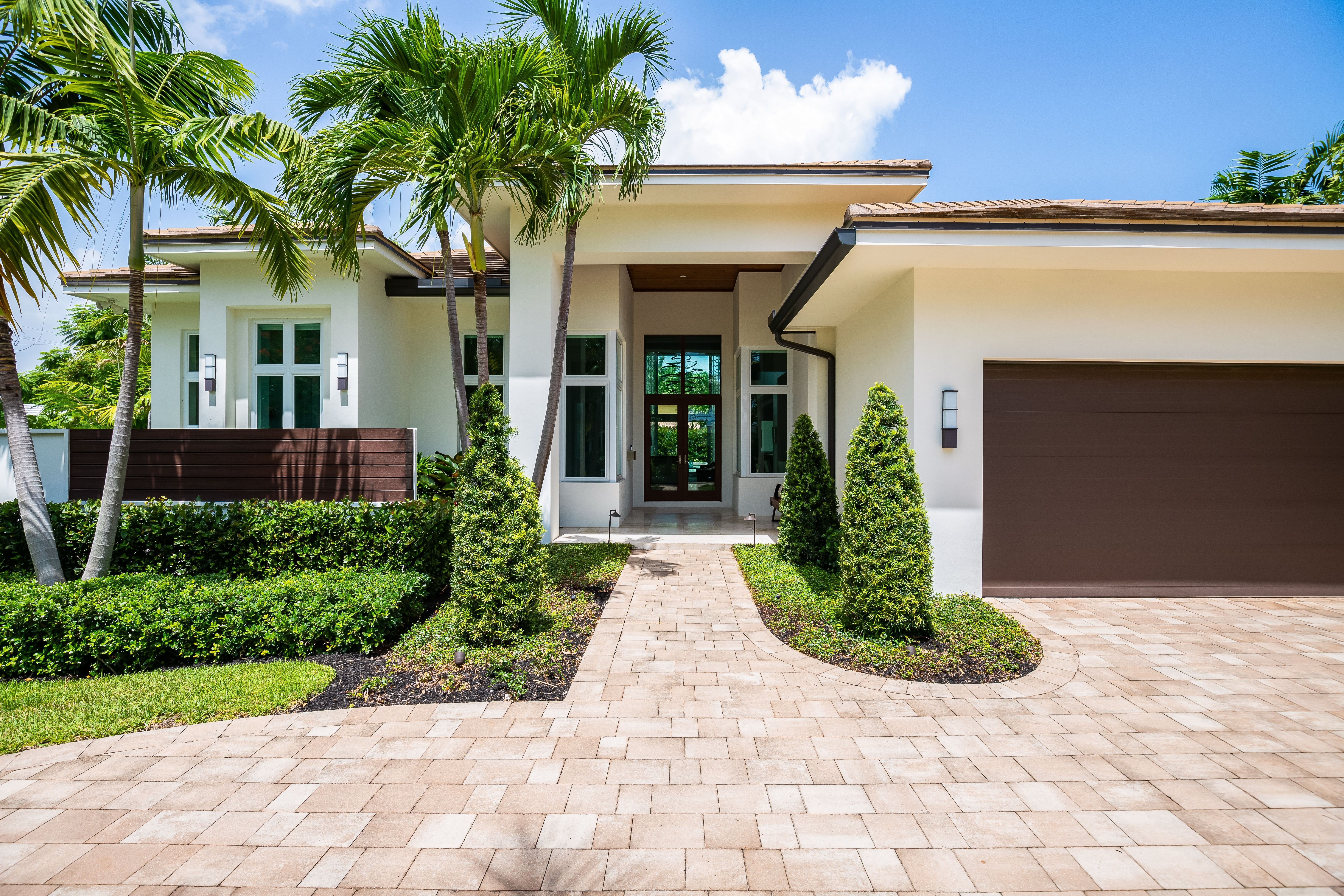 A beautiful home with a paved driveway, showcasing the expertise of concrete contractors. Specializing in driveway construction and paved driveway installation, these professionals are also skilled in paver installation, enhancing the curb appeal of homes in the area.