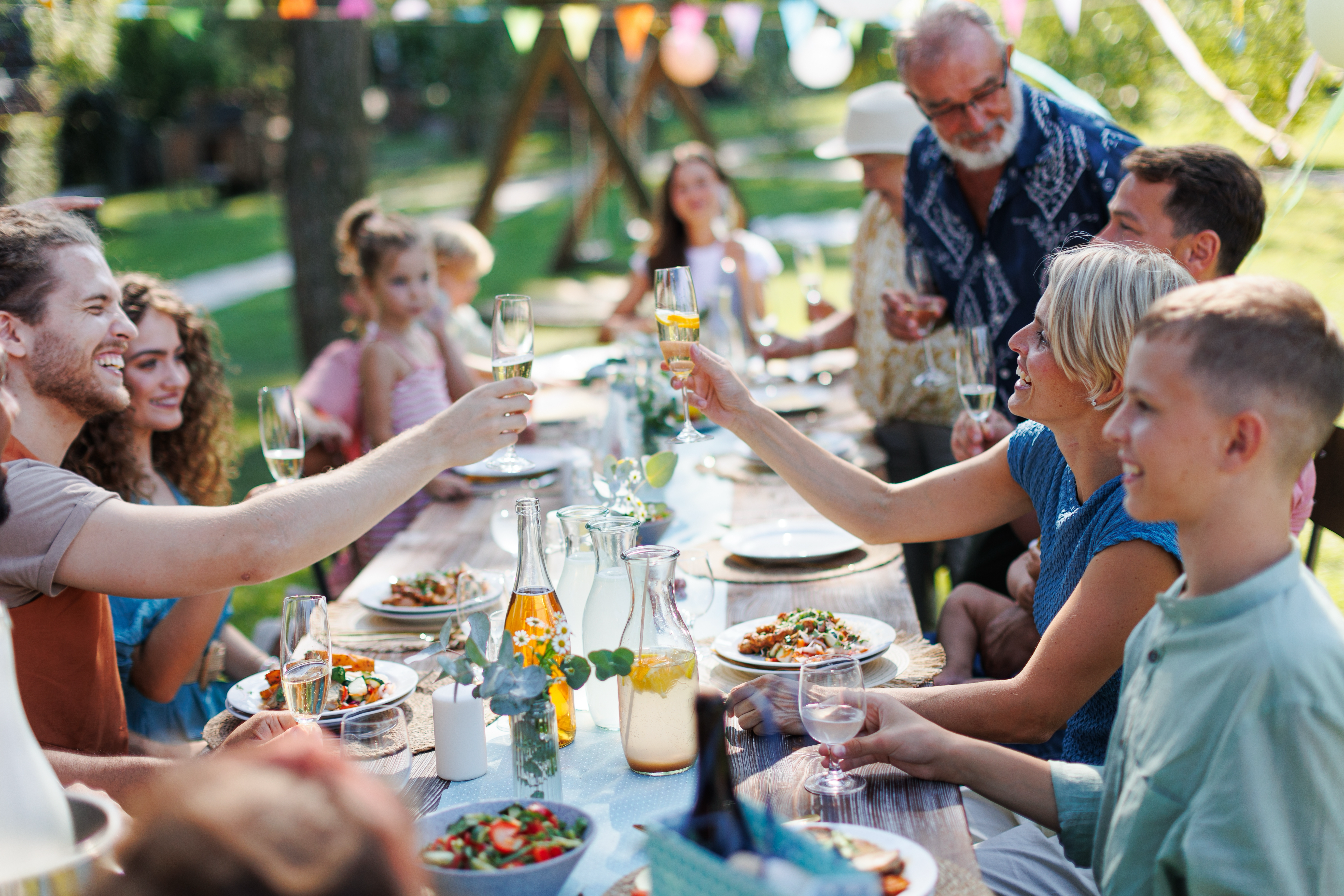 A family celebrating together in their beautifully landscaped backyard in Beverly Hills, featuring a stunning concrete patio designed by a skilled concrete contractor in Beverly Hills, California.