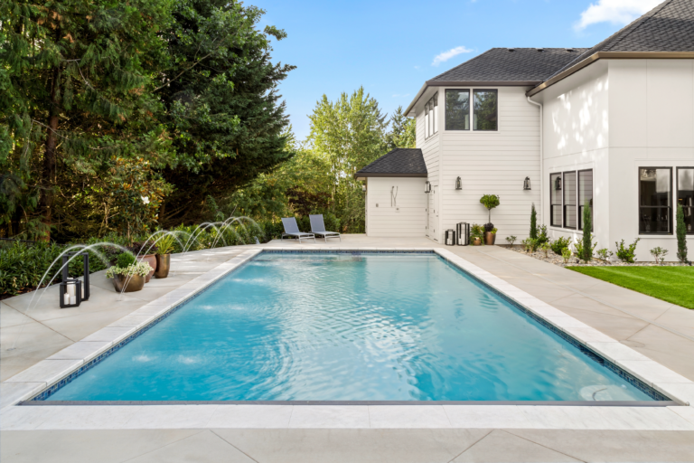 Image showcasing an elaborate backyard pool with stone flooring.