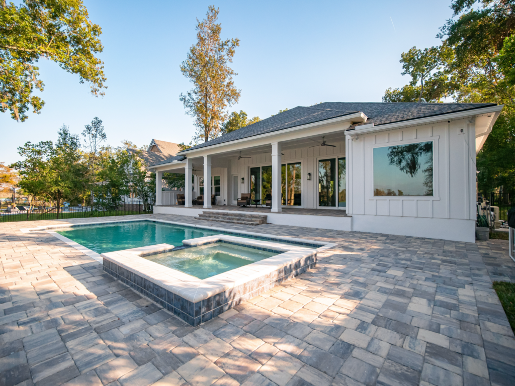 Image showcasing a stunning paver patio by a pool that was installed by a paving contractor.