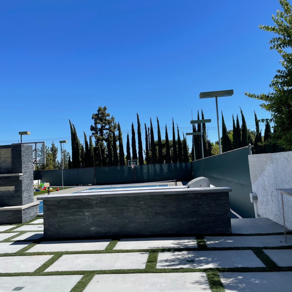 Image showcasing an outdoor kitchen and fireplace with stone veneer panels.